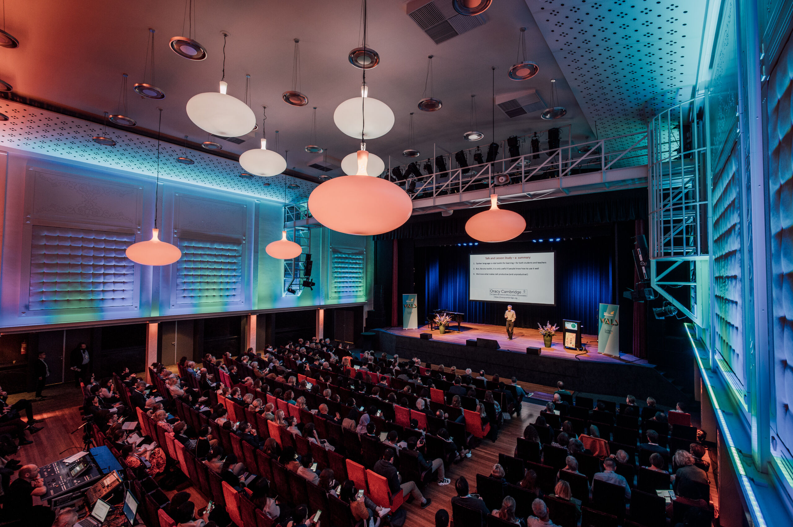 Congres bij Windesheim in Nieuwe Buitensociëteit Zwolle, met deelnemers die aandachtig luisteren naar een spreker op het podium.