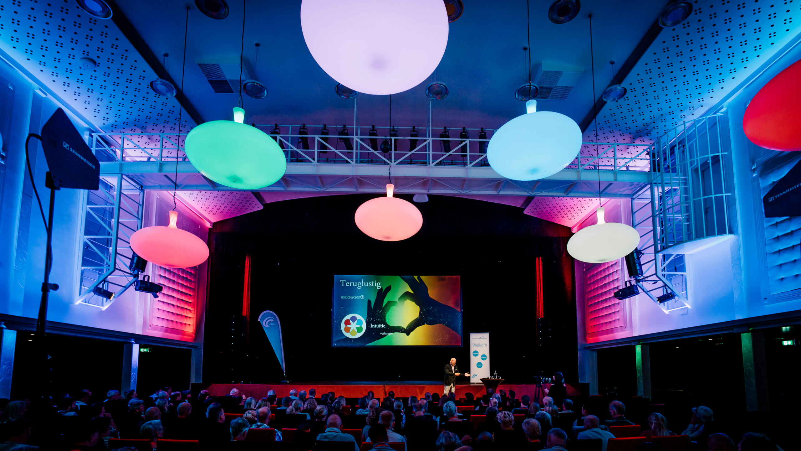 Diverse kleuren lichten aangepast op branding van congres in Theater Buitensoos.