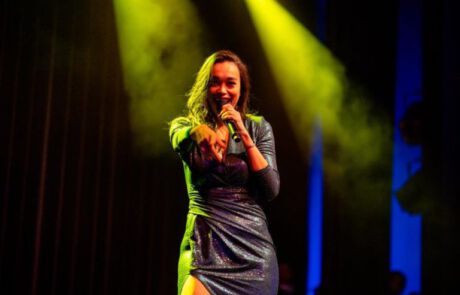Romy Monteiro op podium van Theater Buitensoos tijdens De Sassendonkse Heerenzitting.